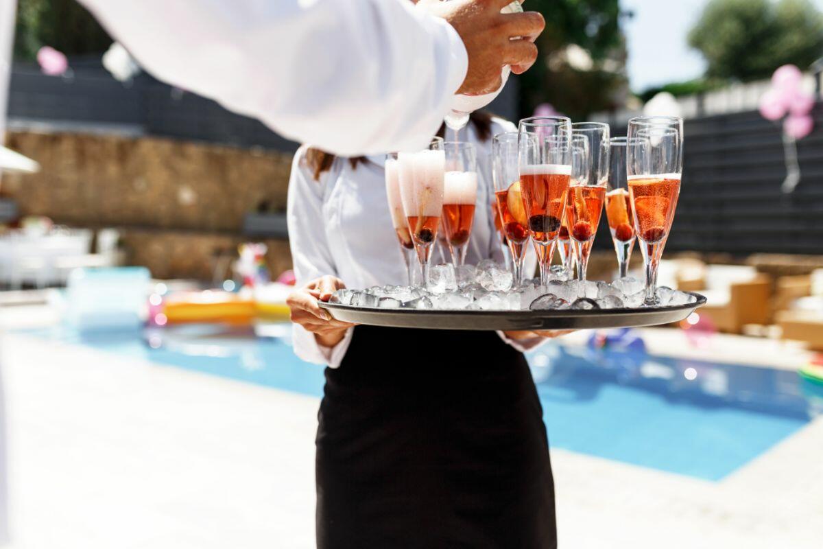 chef privato che serve champagne a bordo piscina in una villa di lusso a ibiza